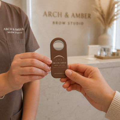 Brow Studio custom logo bottle opener magnet - handed to a customer