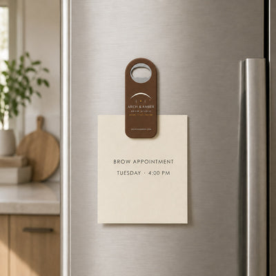 Brow Studio custom logo bottle opener magnet - held on a refrigerator door by its magnetic back