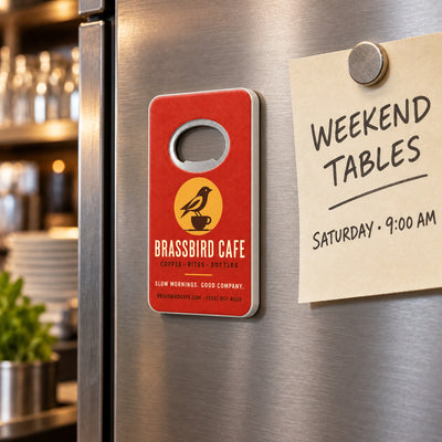 Cafe Logo custom logo bottle opener magnet - held on a refrigerator door by its magnetic back
