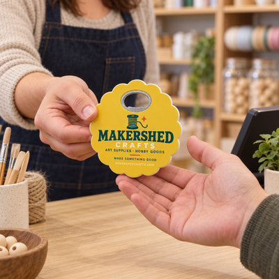 Craft Store custom logo bottle opener magnet - handed to a customer