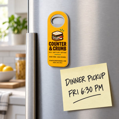 Deli custom logo bottle opener magnet - held on a refrigerator door by its magnetic back