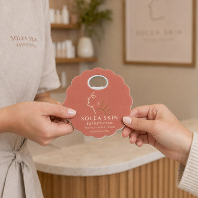Esthetician custom logo bottle opener magnet - handed to a customer