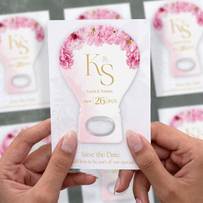 Pink Floral Hot Air Balloon save the date bottle opener magnet shown in hand on its printed background card