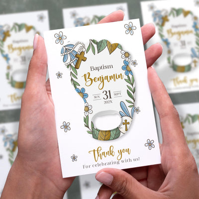 Blue Floral Cross Footprint baptism bottle opener magnet shown in hand on its printed background card