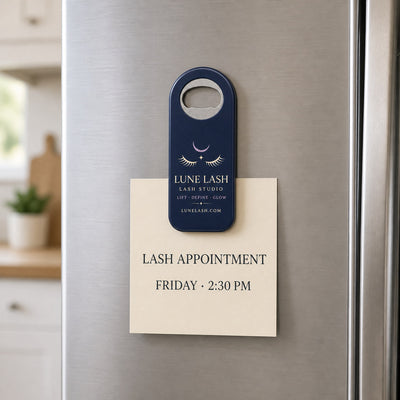 Lash Studio custom logo bottle opener magnet - held on a refrigerator door by its magnetic back