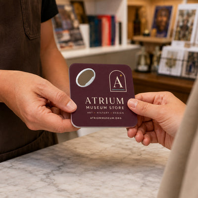 Museum Gift Shop custom logo bottle opener magnet - handed to a customer