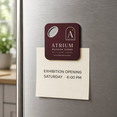 Museum Gift Shop custom logo bottle opener magnet - held on a refrigerator door by its magnetic back