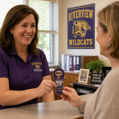 School Booster Club custom logo bottle opener magnet - handed to a customer
