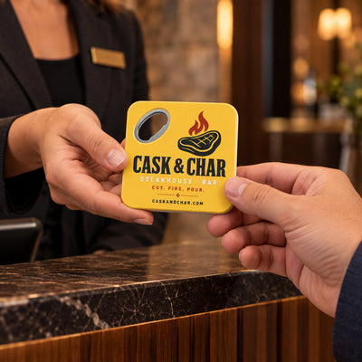 Steakhouse custom logo bottle opener magnet - handed to a customer